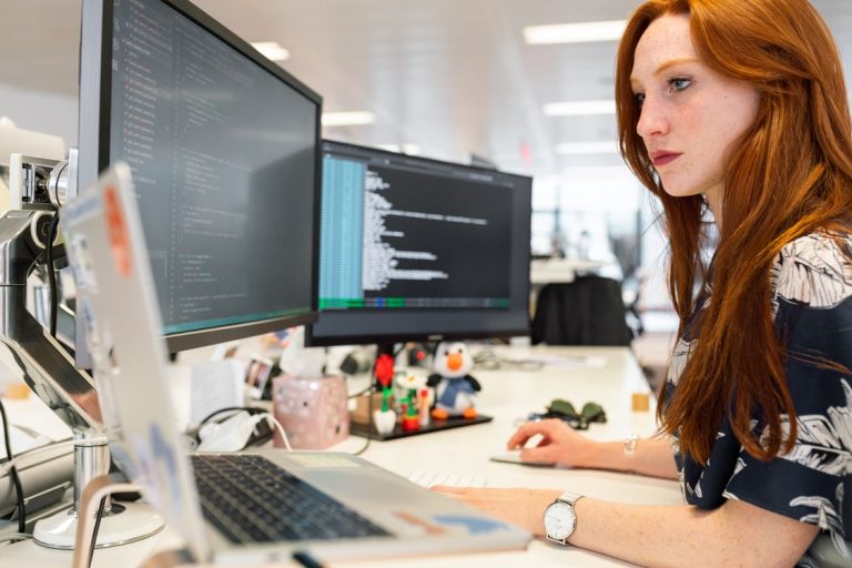 Developer looking at code on a monitor representing WordPress debugging