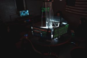 Hacker using laptop in dark room representing credential stuffing attack on WordPress