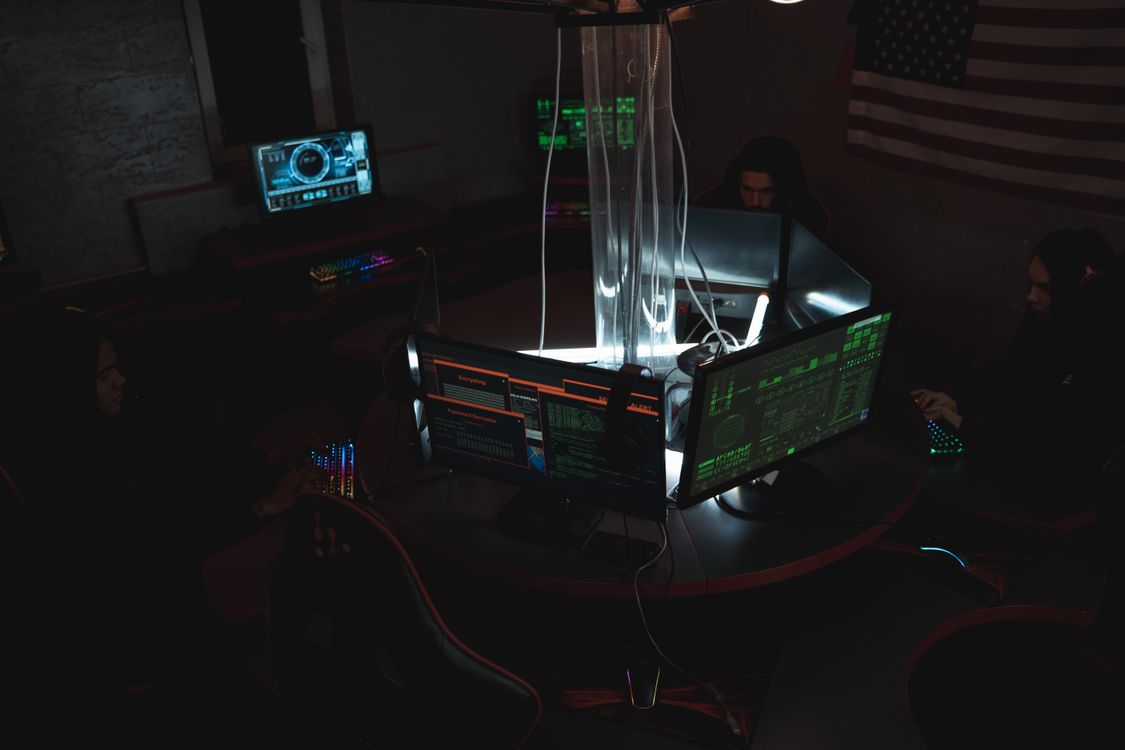 Hacker using laptop in dark room representing credential stuffing attack on WordPress